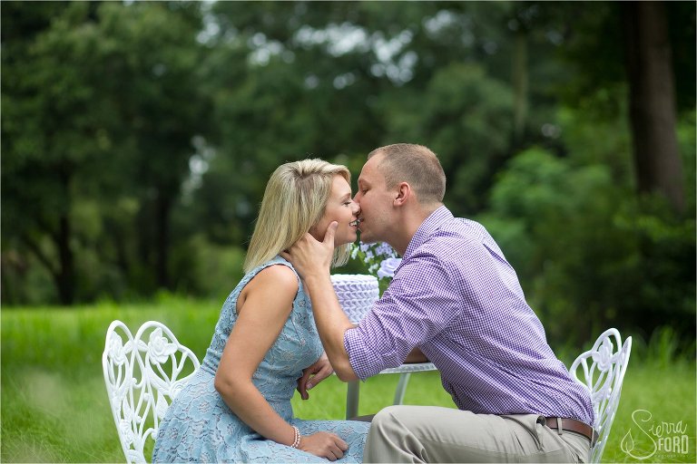 Couple kissing during unique engagement session with cupcake theme
