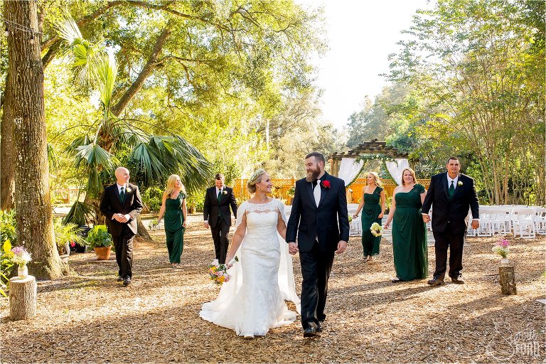 Bridal party walking and talking through Harmony Gardens