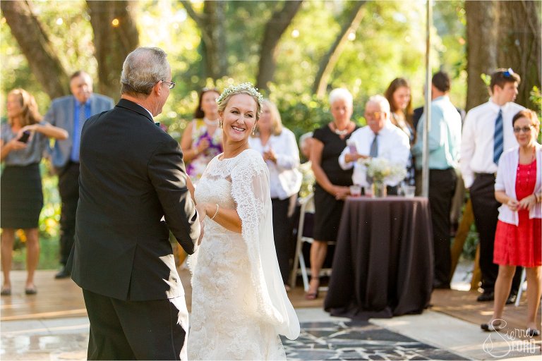 Father and daughter dance together in garden reception