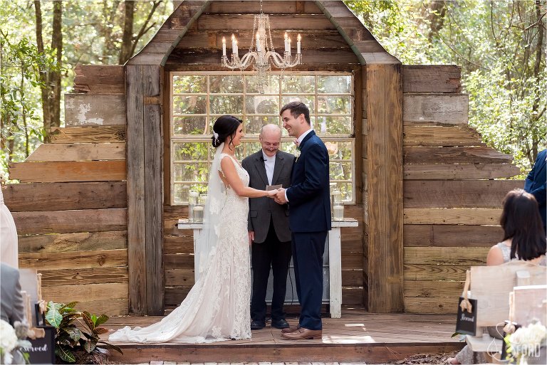 Bride and groom at farm inspired altar with chandelier