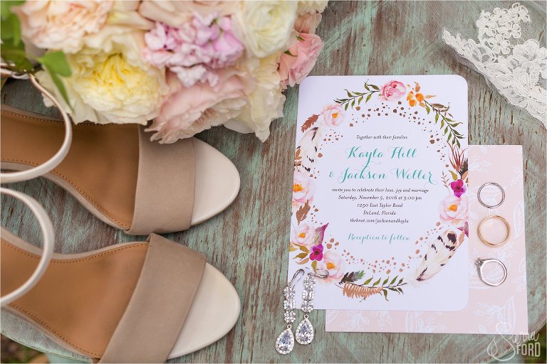 Wedding details inclduing rings, invitations, and flowers