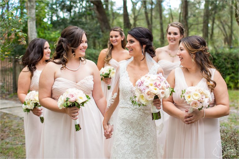 Bride and bridesmaids walking in barn field