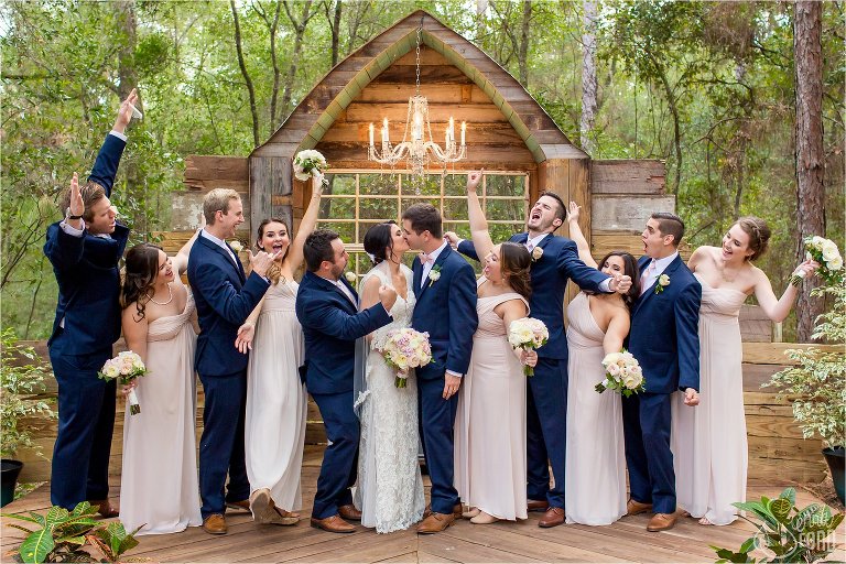 Bridal party cheers at altar for couple kissing