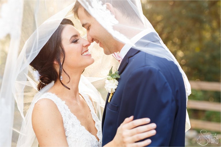 Bride and groom under veil at Bridle Oaks wedding