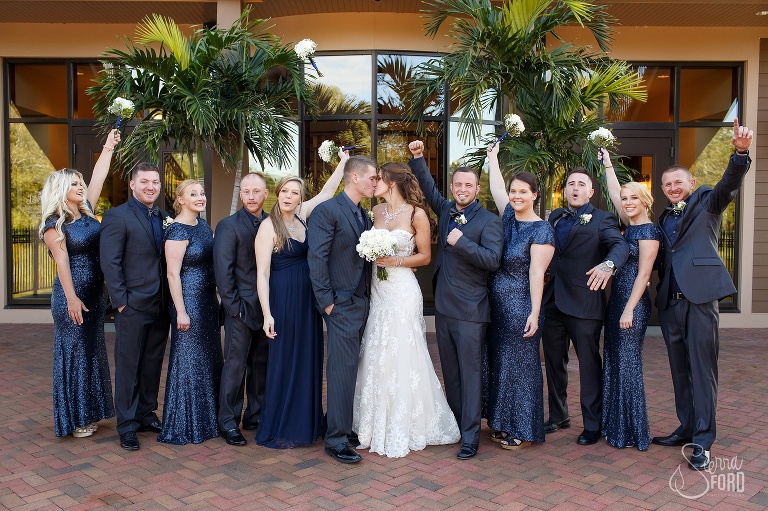 Bridal party cheerings for kissing couple