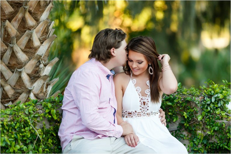 She fixes her hair while he kisses her cheek