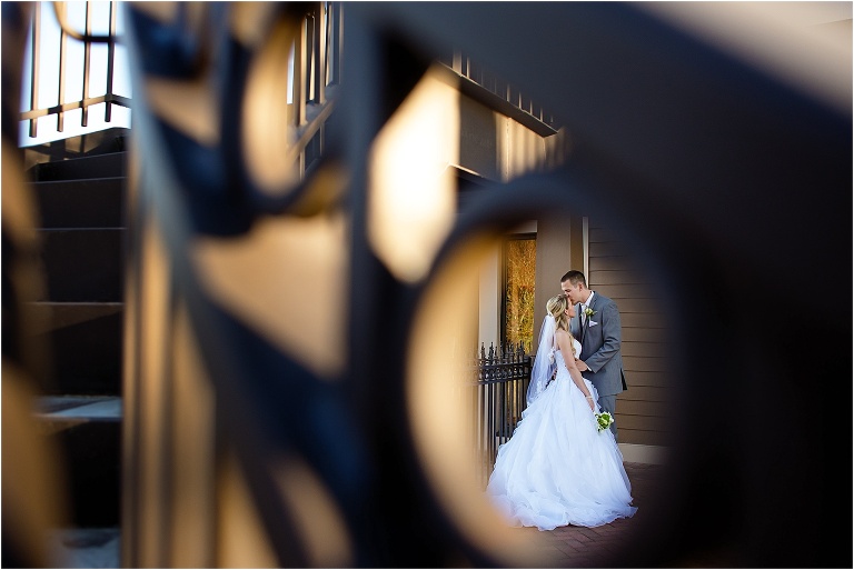 Wedding photo of husband kissing wife through the stairwell railing at Tavares Pavilion