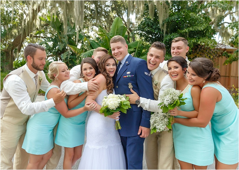 The bridesmaids & groomsmen surrounding the bride and groom with love and congratulations