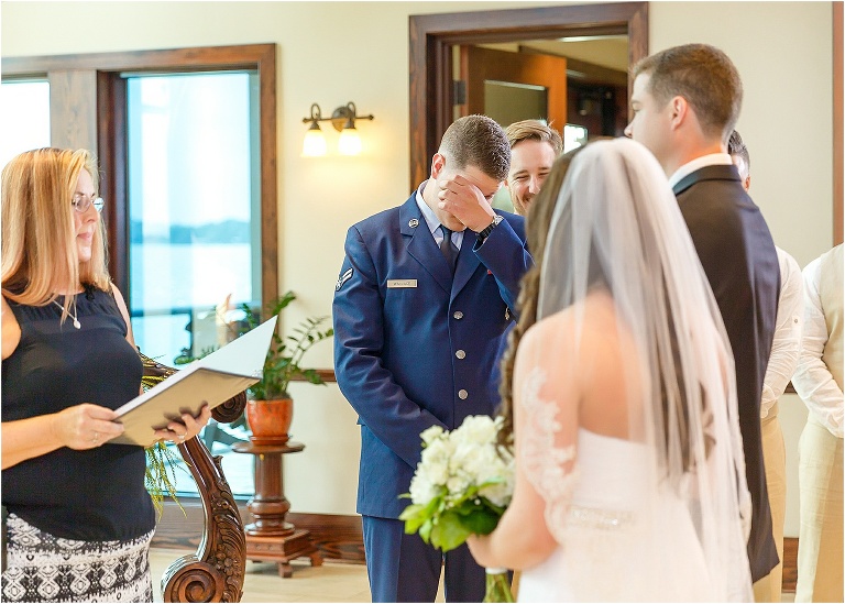 The groom wipes away a tear as he receives his bride from her brother
