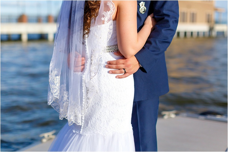 Bride & groom together on the scenic boat dock, highlighting the gorgeous detail on the bride's David's Bridal dress