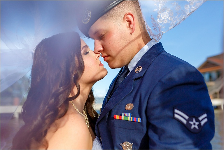 Bride & groom under veil lakeside at Tavares Pavilion wedding