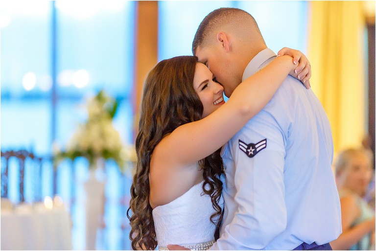 Bride smiles as her new husband sings their first dance song in her ear