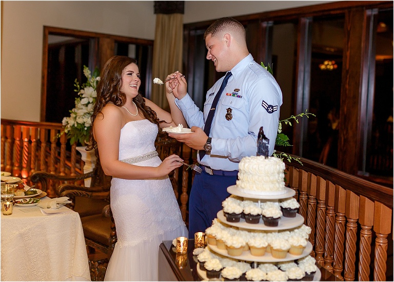 Groom attempting to feed his bride their cake from Cupcake Delights