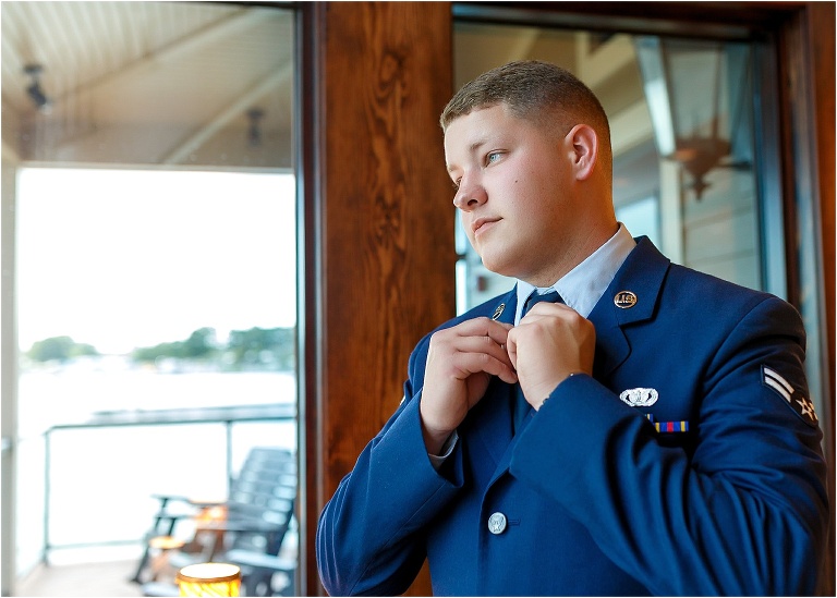 Groom fixing his tie as he prepares to marry his bride