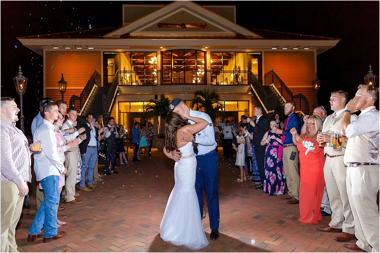 Bride & groom share one last kiss during their bubble filled grand exit surrounded by their friends and family