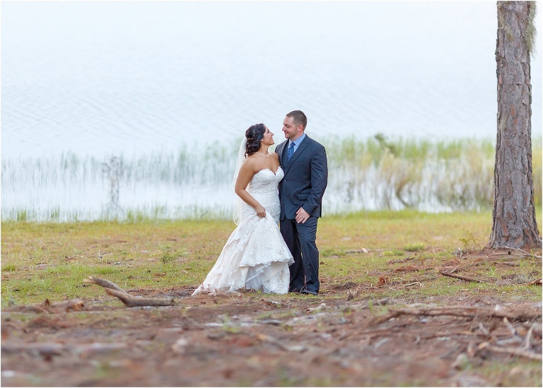 the couple shares a quiet moment with a lovely lake behind them