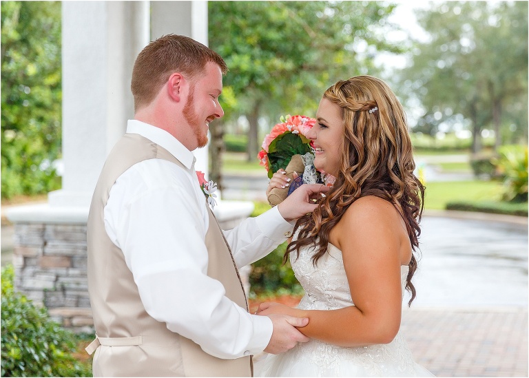 the groom adjusting the bride's necklace