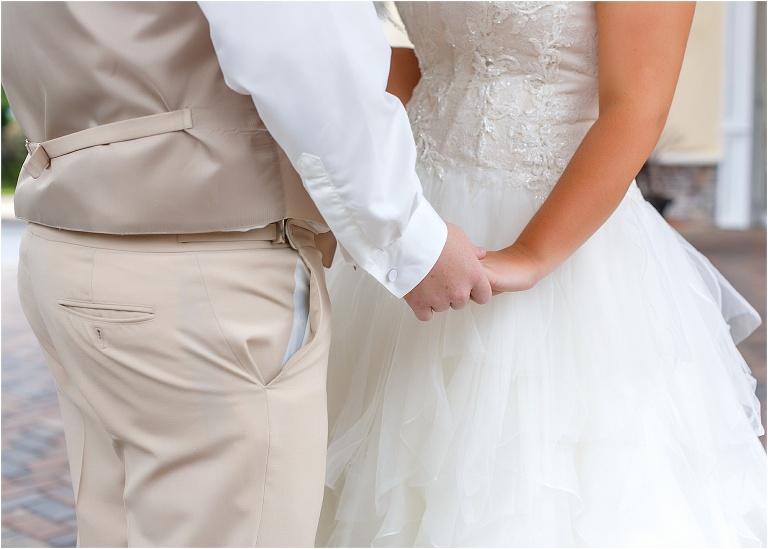 a close up shot of the bride and groom holding hands