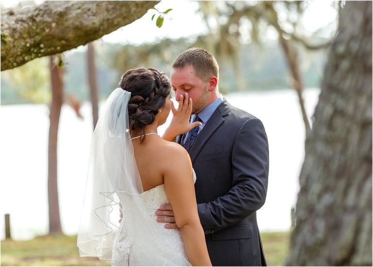 the bride wipes tears from the groom's face during their first look