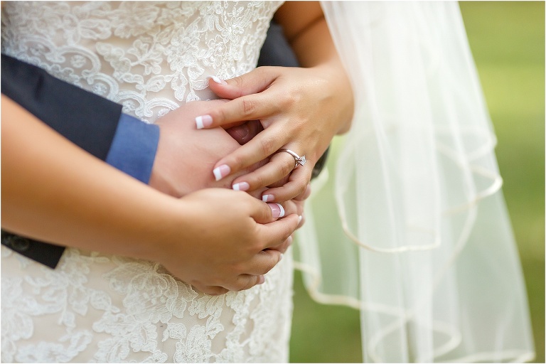 a closeup shot of the couple's hands intertwined