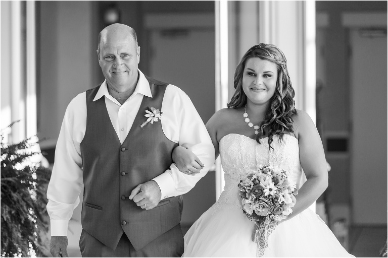the father of the bride proudly walking his daughter down the aisle