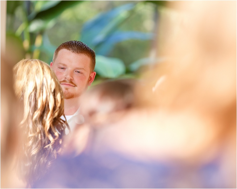 a peek of the groom admiring his bride through the crowd