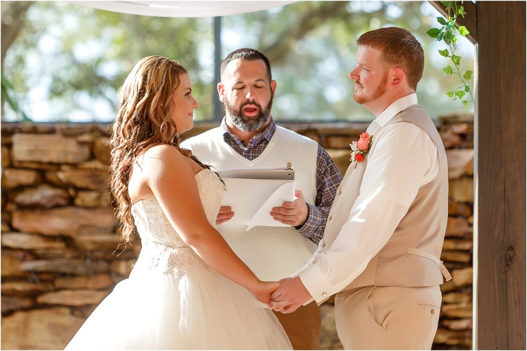 the bride and groom smile at each other as the ceremony begins