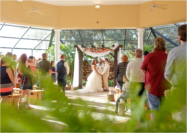 friends and family look on as the bride and groom exchange vows
