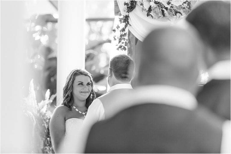a peek of the bride admiring her groom through the crowd