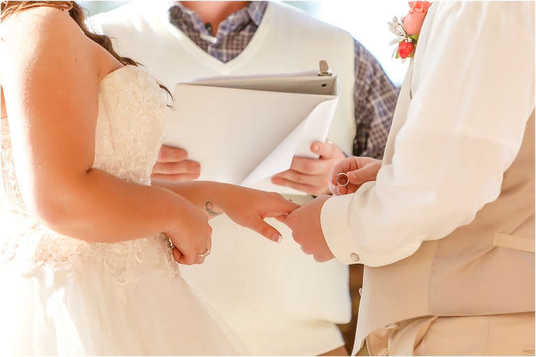 the groom prepares to place the ring on his bride's finger