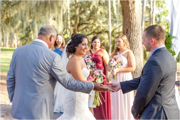 The father of the bride gives his daughter away to the groom