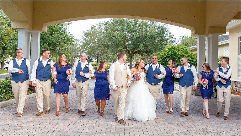 bride & groom surrounded by their wedding party taking a stroll