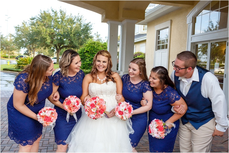 the bride shares a laugh with her bridesmaids and man of honor