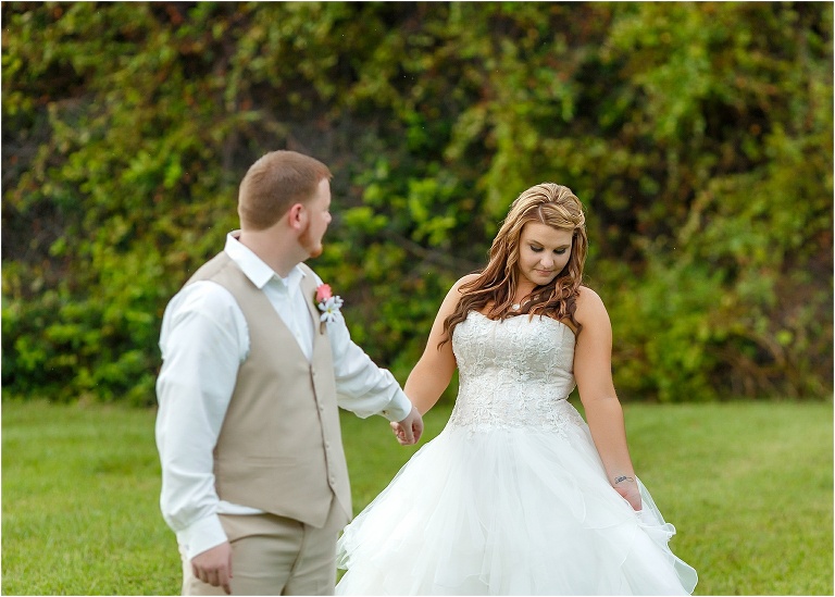 the bride showing off her dress to her new husband