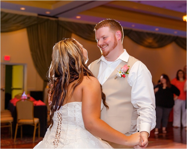 the bride and groom share a laugh during their first dance