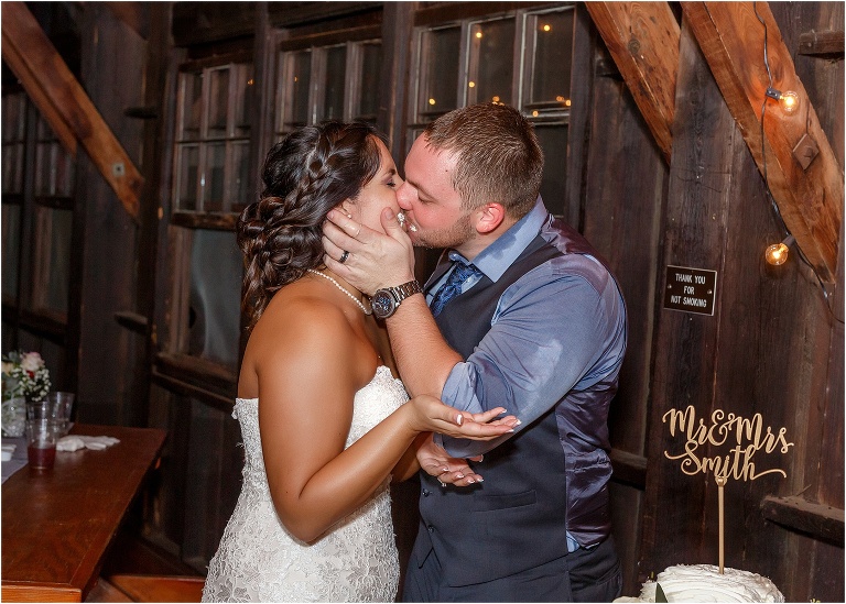 Bride and groom share a cake covered kiss