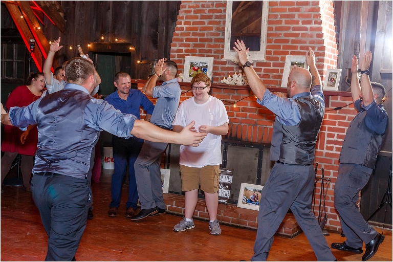 The groom & groomsmen celebrate the young man who caught the garter