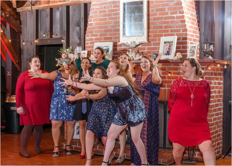 The ladies all reach for the bride's bouquet