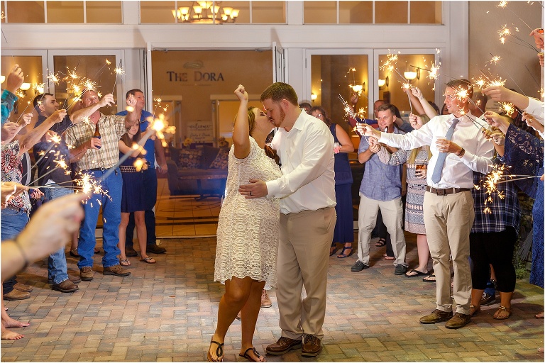 the bride and groom kiss during their sparkler grand exit