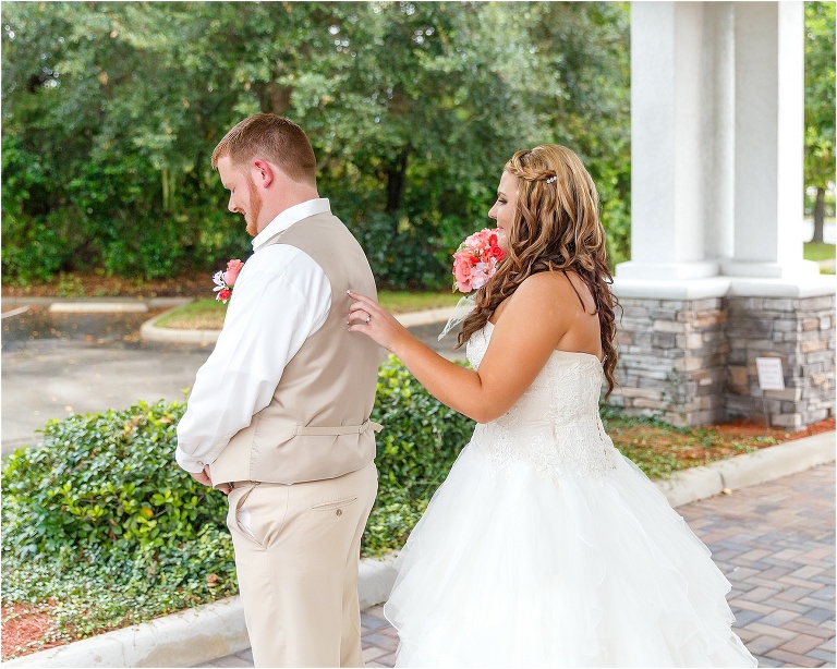 the bride taps the groom on the shoulder so he can get his first look of his future wife in her dress