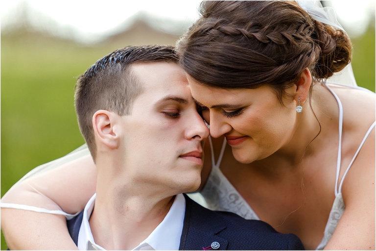 the bride and groom snuggle up close for a quiet moment together