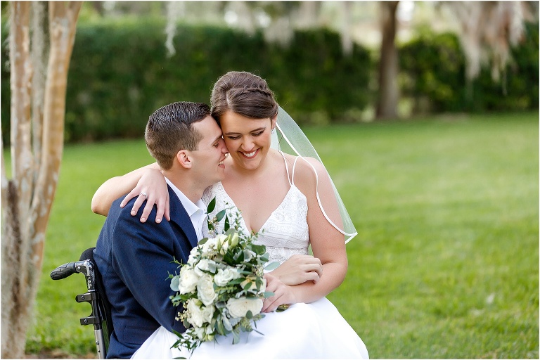 the groom nuzzles the bride's cheek while she sits on his lap