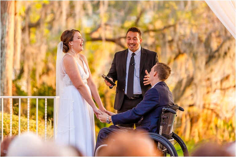 the bride and groom laugh hysterically as their good friend and officiant, Bobby Brooks, cracks a joke during their ceremony