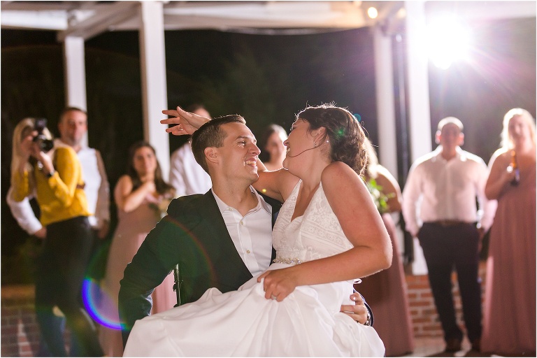 the groom takes his bride for a spin in his wheelchair during their first dance while she laughs
