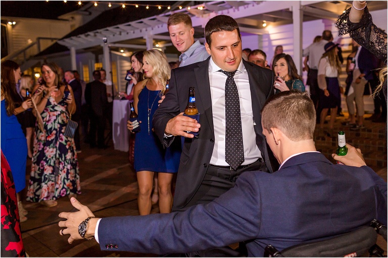 the groom's friends competing with the groom for who has the best dance moves under the market lights at Cypress Grove