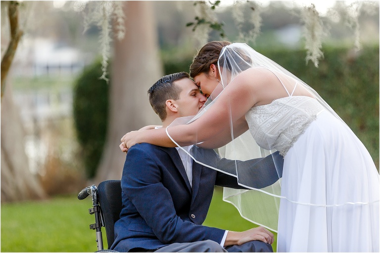 the bride & groom forehead to forehead with Lake Jessamine behind them