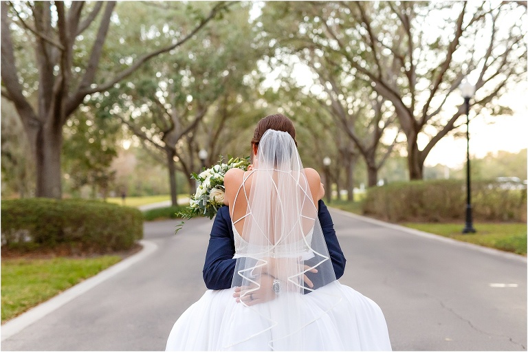 the back of the bride's Hayley Paige dress as her groom hugs her tightly