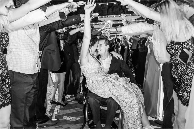 the bride and groom share a moment as they exit their gorgeous reception through a human tunnel of their friends and family at the Estate House at Cypress Grove