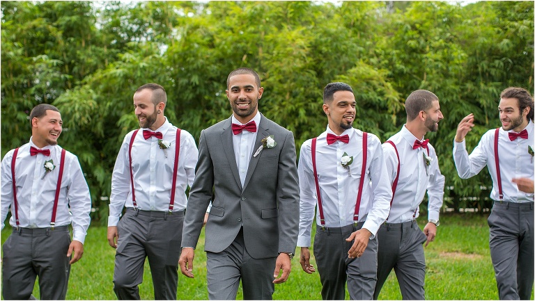 the groom smiles as he and his groomsmen take a stroll through the property