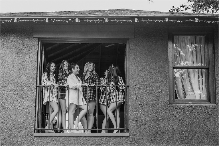 bride and her bridesmaids giggling in the window in matching flannels